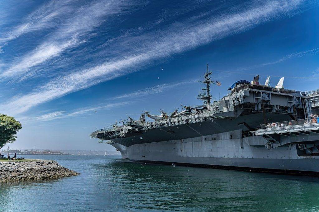 USS Midway Museum ship docked in San Diego harbor on a clear day, showcasing naval history.