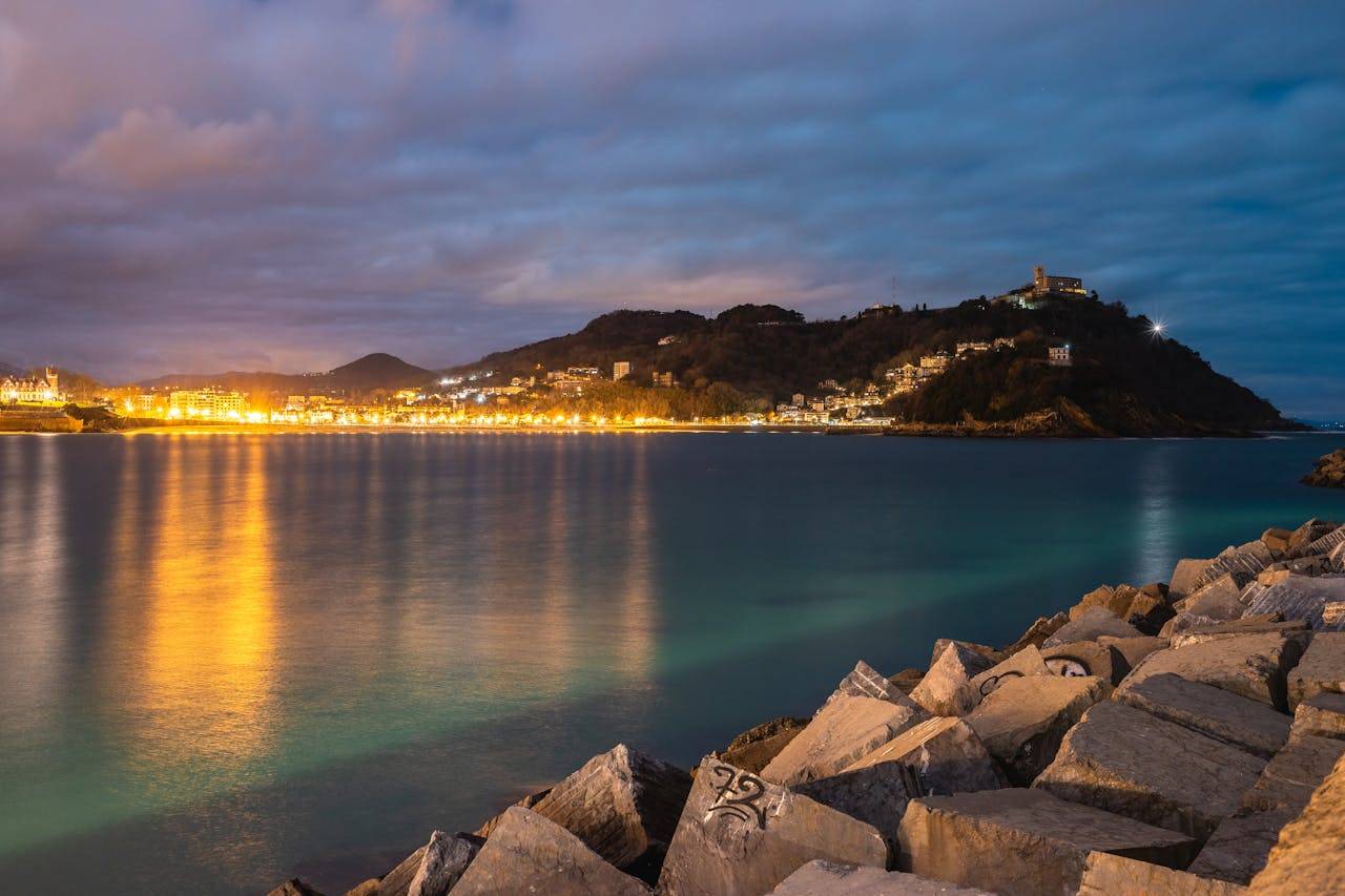 Capture of San Sebastians coastline at night, showcasing shimmering lights and a serene seascape.